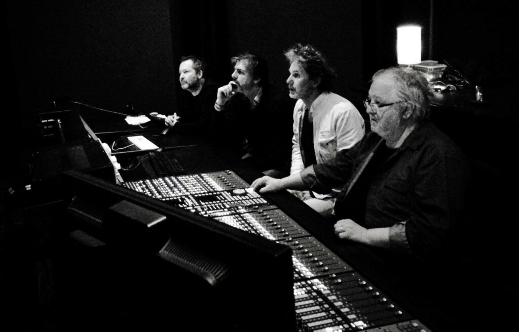 black and white image of a team intently concentrating on mixing the soundtrack